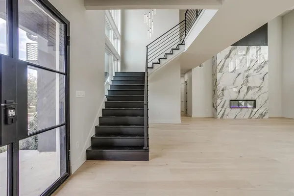 a view of staircase with lots of frames on wall and windows