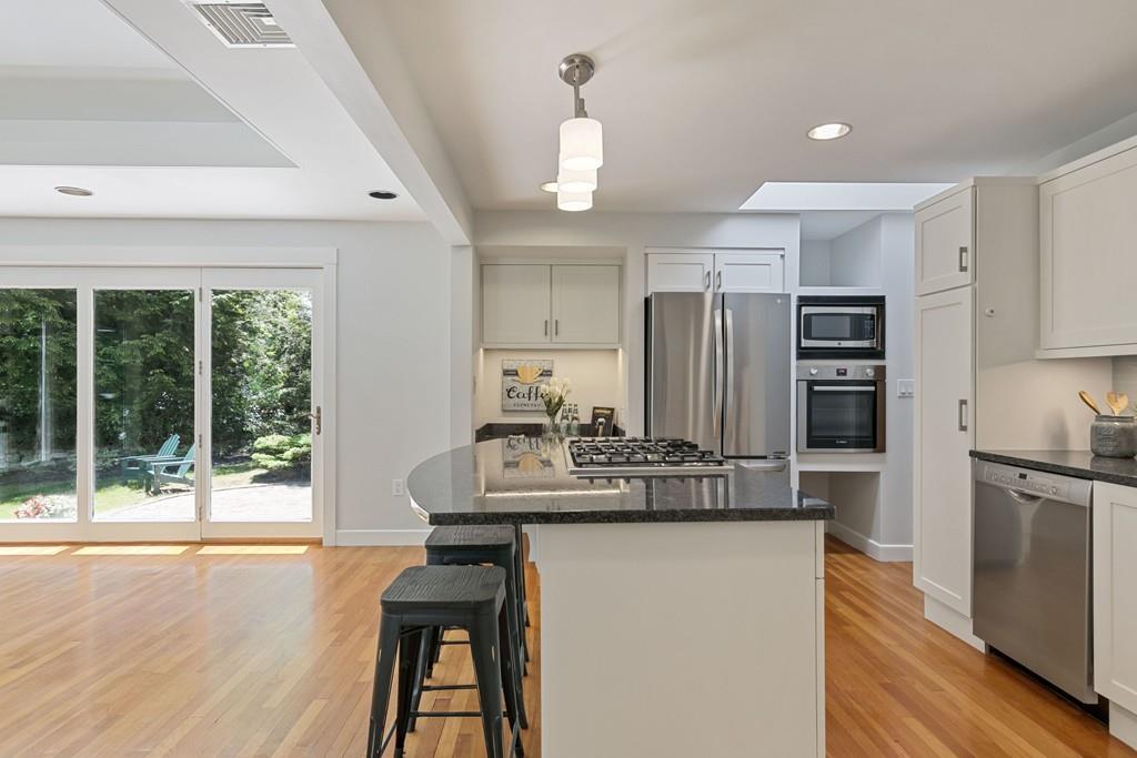 9 Baskin Road Lexington, MA 02421 - Photo 11 of 39 a kitchen with kitchen island a counter top space a sink stainless steel appliances and cabinets