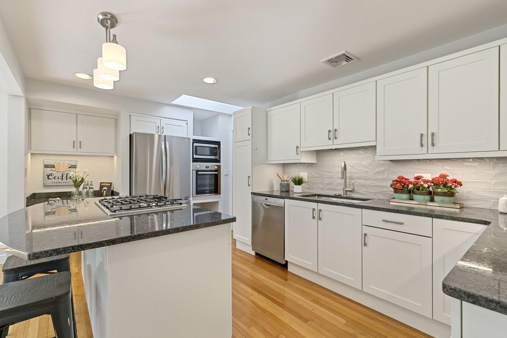 9 Baskin Road Lexington, MA 02421 - Photo 12 of 39 a kitchen with kitchen island granite countertop a sink cabinets and stainless steel appliances