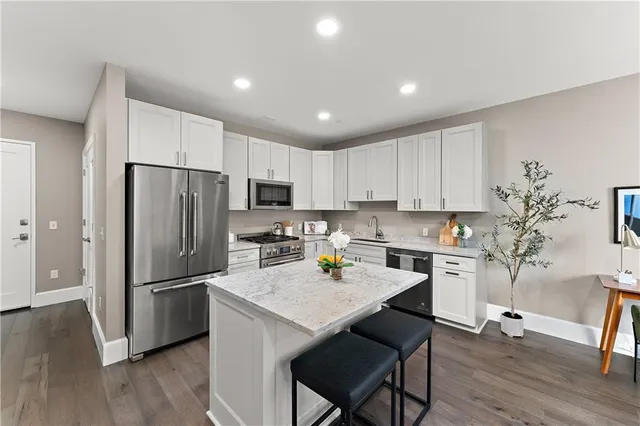 a kitchen with stainless steel appliances granite countertop a sink stove and refrigerator