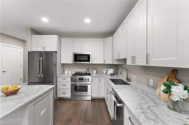 a kitchen with stainless steel appliances granite countertop a sink stove and cabinets
