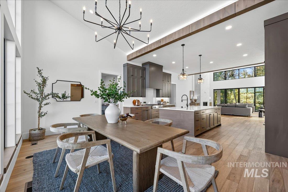 665 Watkins Street Middleton, ID 83644 - Photo 8 of 34 Dining area featuring a towering ceiling, light wood-style floors, recessed lighting, and a chandelier