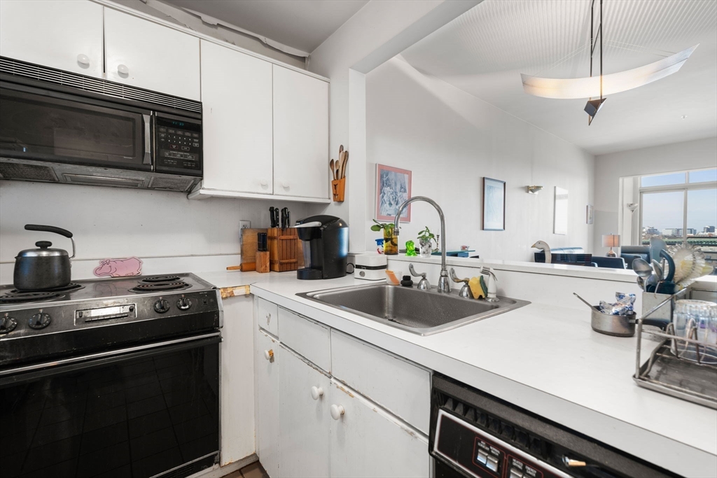 197 8th Street, Unit 728 Boston, MA 02129 - Photo 6 of 29 a kitchen with a sink a stove and microwave