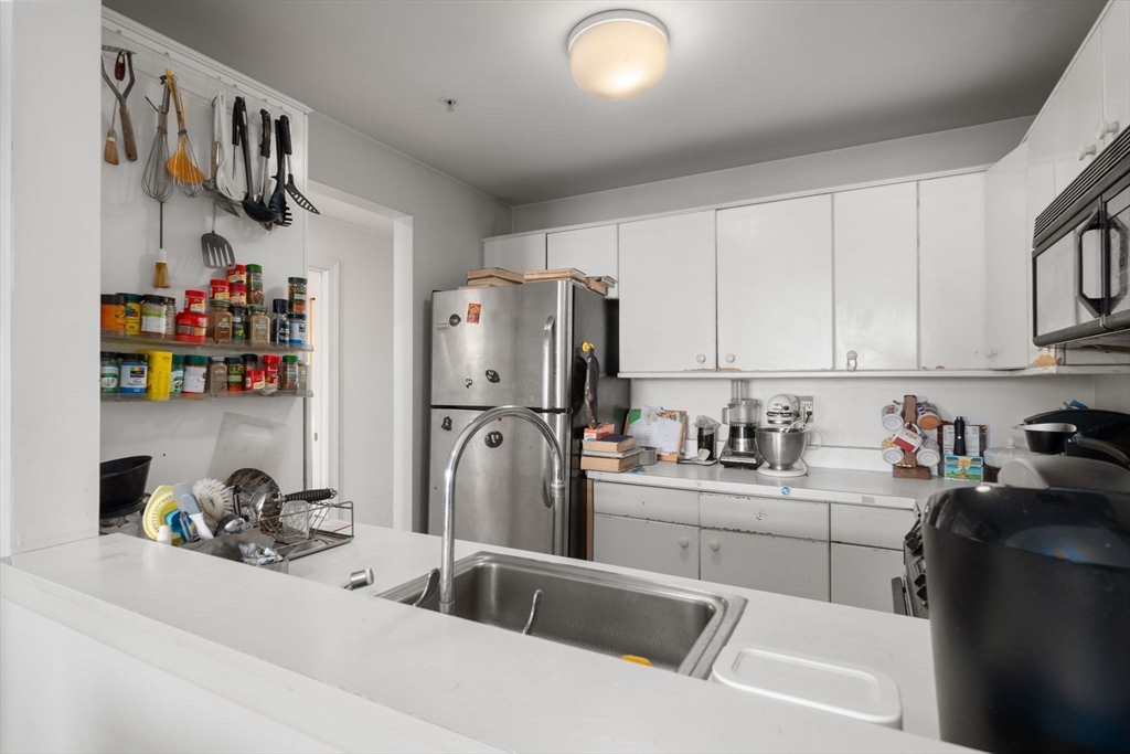 197 8th Street, Unit 728 Boston, MA 02129 - Photo 7 of 29 a kitchen with stainless steel appliances a sink a refrigerator and cabinets