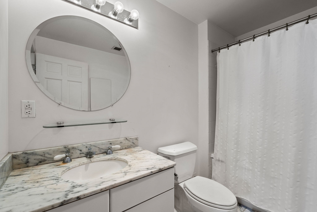 197 8th Street, Unit 728 Boston, MA 02129 - Photo 9 of 29 a bathroom with a granite countertop sink mirror vanity and toilet