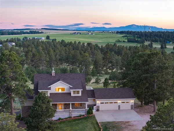 an aerial view of a house with a garden and a lake view