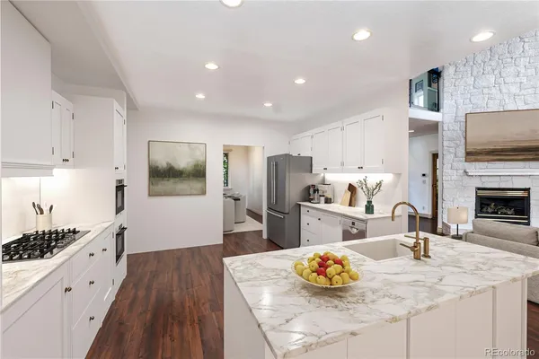 a kitchen with stainless steel appliances kitchen island granite countertop a sink refrigerator and cabinets