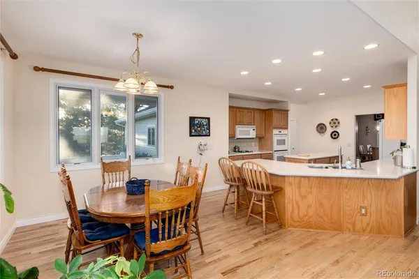 a view of a dining room and livingroom with furniture wooden floor a chandelier