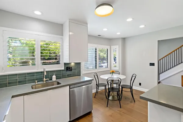 a kitchen with granite countertop a sink dining table and chairs