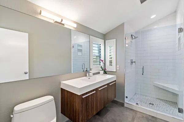 a bathroom with a sink a toilet and shower