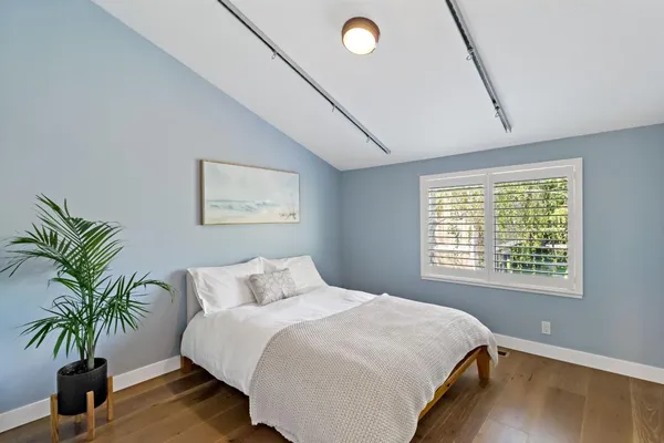 a bedroom with a bed and a potted plant