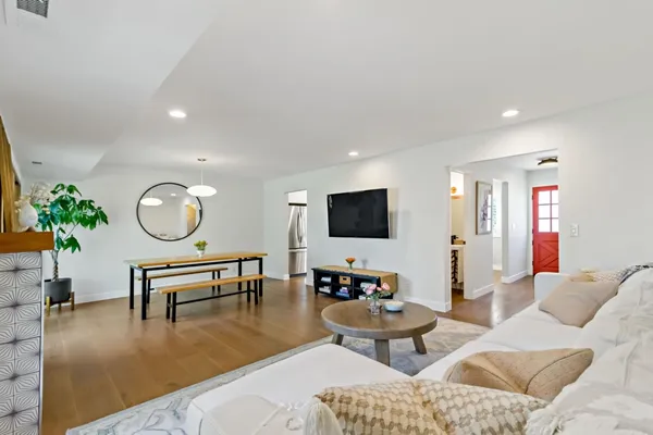 a living room with furniture a rug and a flat screen tv