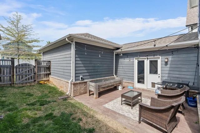 a backyard of a house with table and chairs