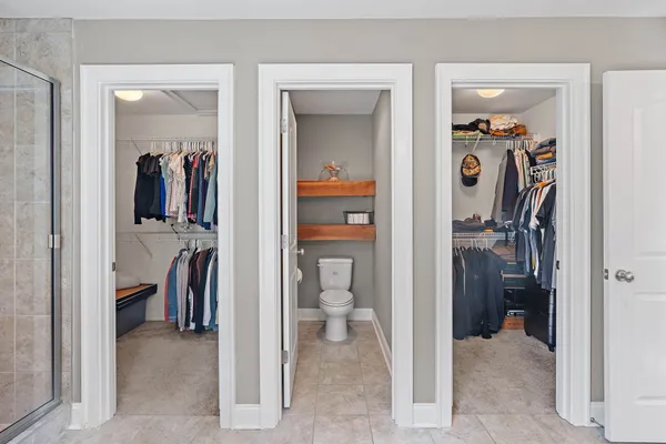 a view of a walk in closet and a bathroom