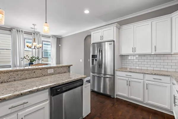 a kitchen with stainless steel appliances granite countertop a refrigerator and a sink