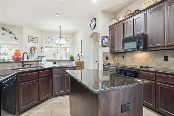 a kitchen with stainless steel appliances granite countertop a refrigerator and a stove