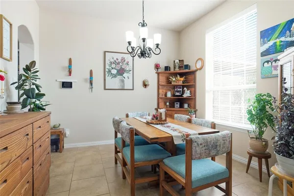 a dining room with furniture potted plants and wooden floor