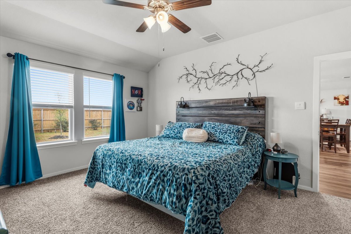 402 Perry Place Rockdale, TX 76567 - Photo 13 of 31 Bedroom featuring carpet flooring, vaulted ceiling, and a ceiling fan
