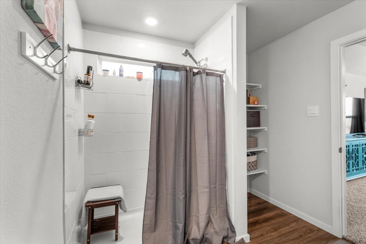 402 Perry Place Rockdale, TX 76567 - Photo 16 of 31 Bathroom with a shower stall and dark wood-style flooring