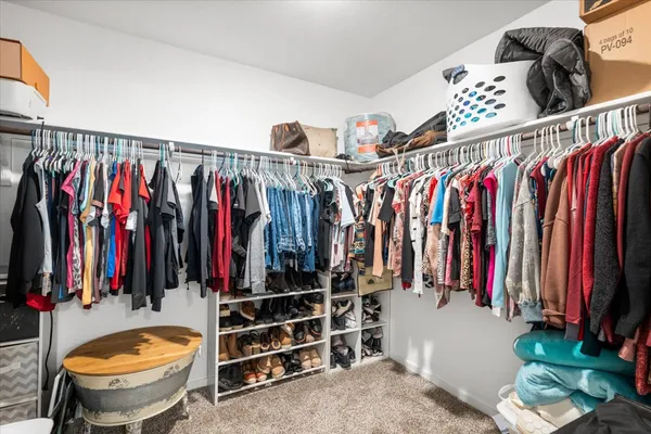 a view of walk in closet with clothes