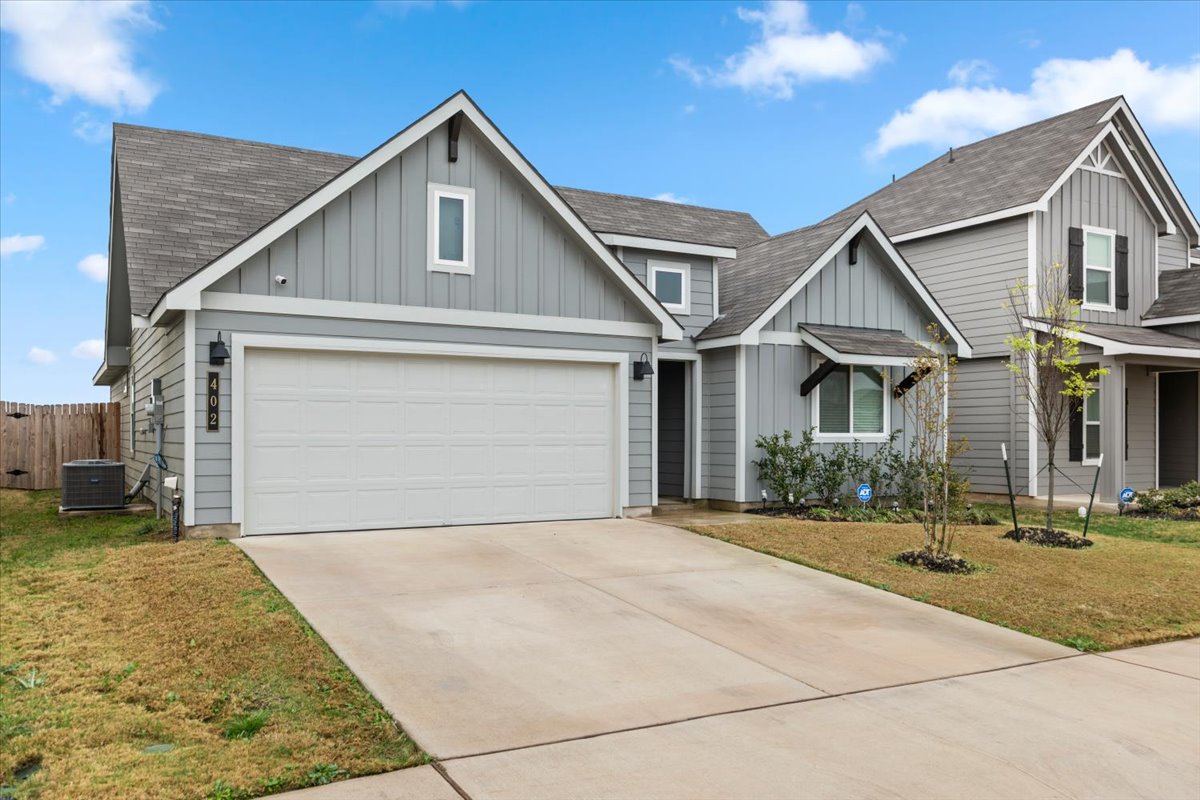 402 Perry Place Rockdale, TX 76567 - Photo 2 of 31 View of front facade with board and batten siding, a shingled roof, and concrete driveway