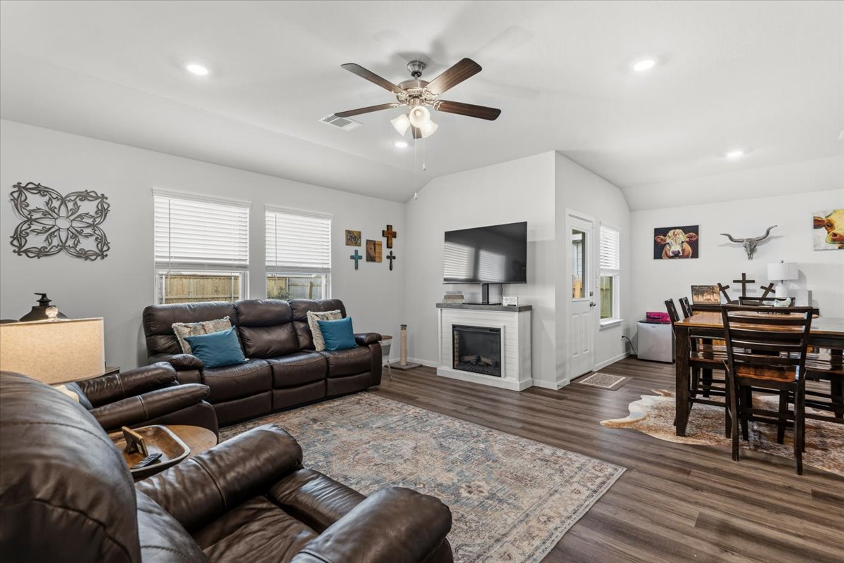 402 Perry Place Rockdale, TX 76567 - Photo 22 of 31 Living room with a ceiling fan, recessed lighting, dark wood-style floors, lofted ceiling, and a fireplace