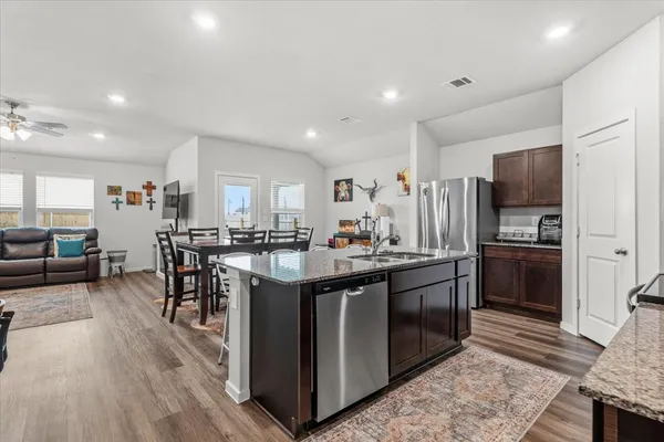 a kitchen with stainless steel appliances granite countertop a sink stove and refrigerator