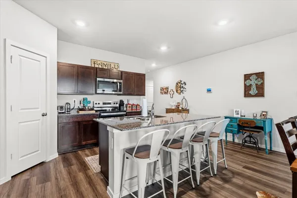 a kitchen with stainless steel appliances a table and chairs in it