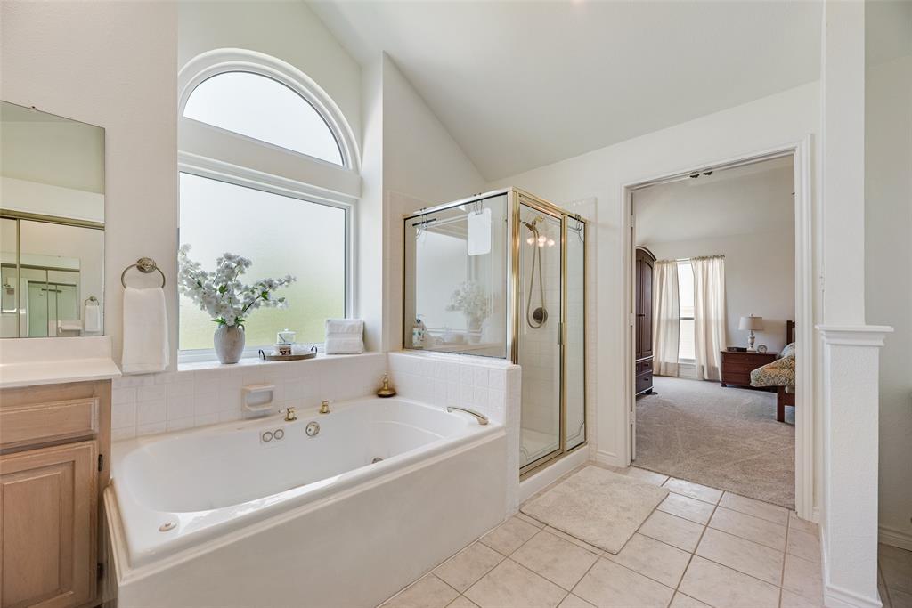 1406 West Peters Colony Road Carrollton, TX 75007 - Photo 12 of 29 a bathroom with a bathtub and a shower