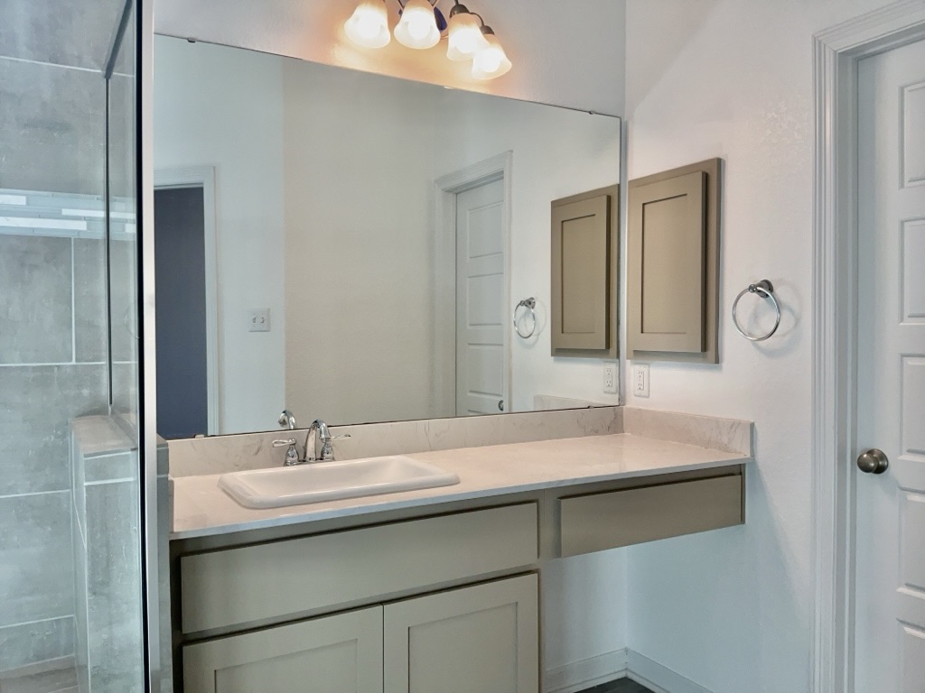 18005 Pomelo Lane, Unit A Pflugerville, TX 78660 - Photo 14 of 28 a bathroom with a sink and a mirror