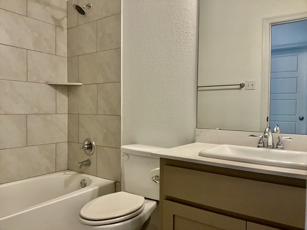 18005 Pomelo Lane, Unit A Pflugerville, TX 78660 - Photo 21 of 28 a bathroom with a sink toilet vanity and shower