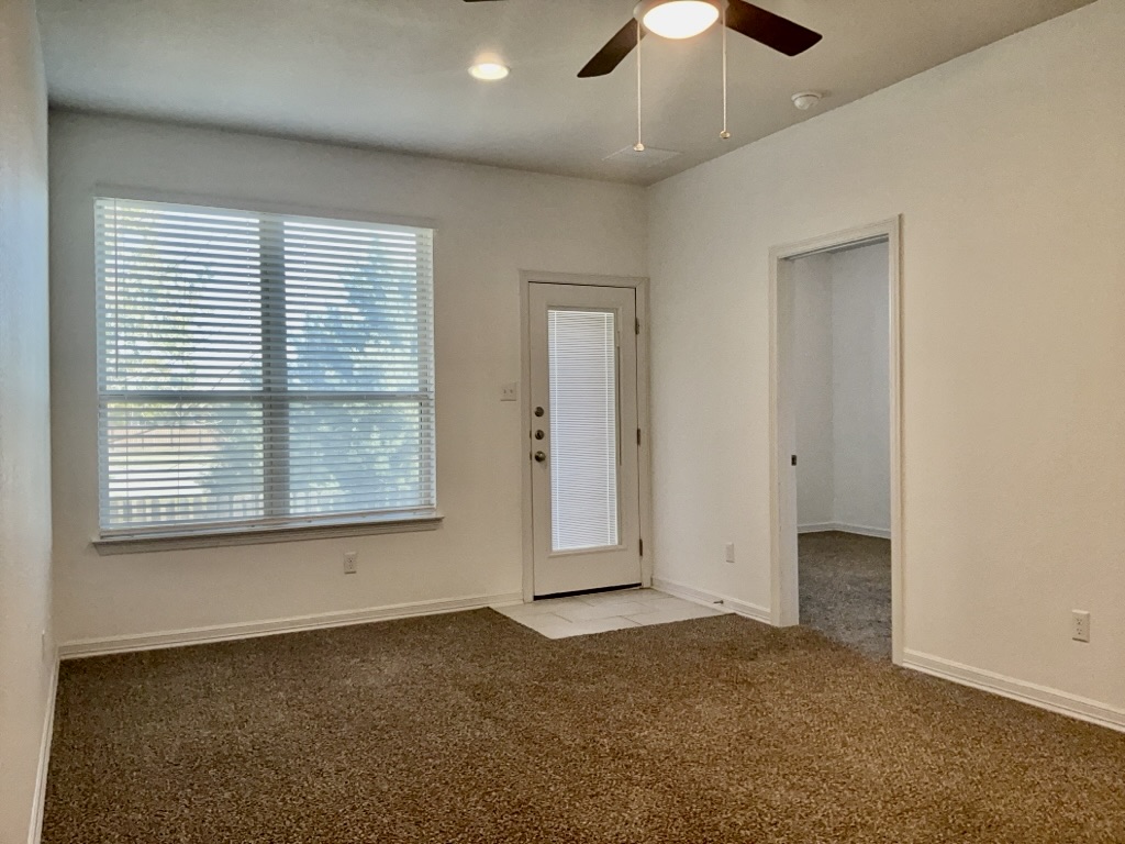 18005 Pomelo Lane, Unit A Pflugerville, TX 78660 - Photo 23 of 28 an empty room with chandelier fan and windows