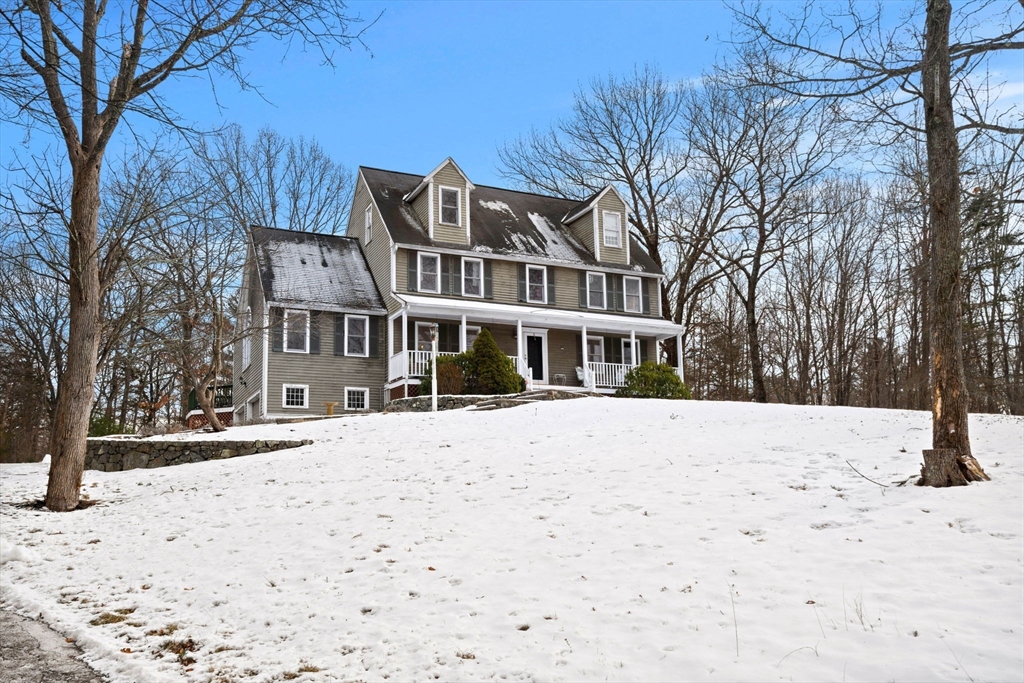 a front view of a building with a yard covered in snow