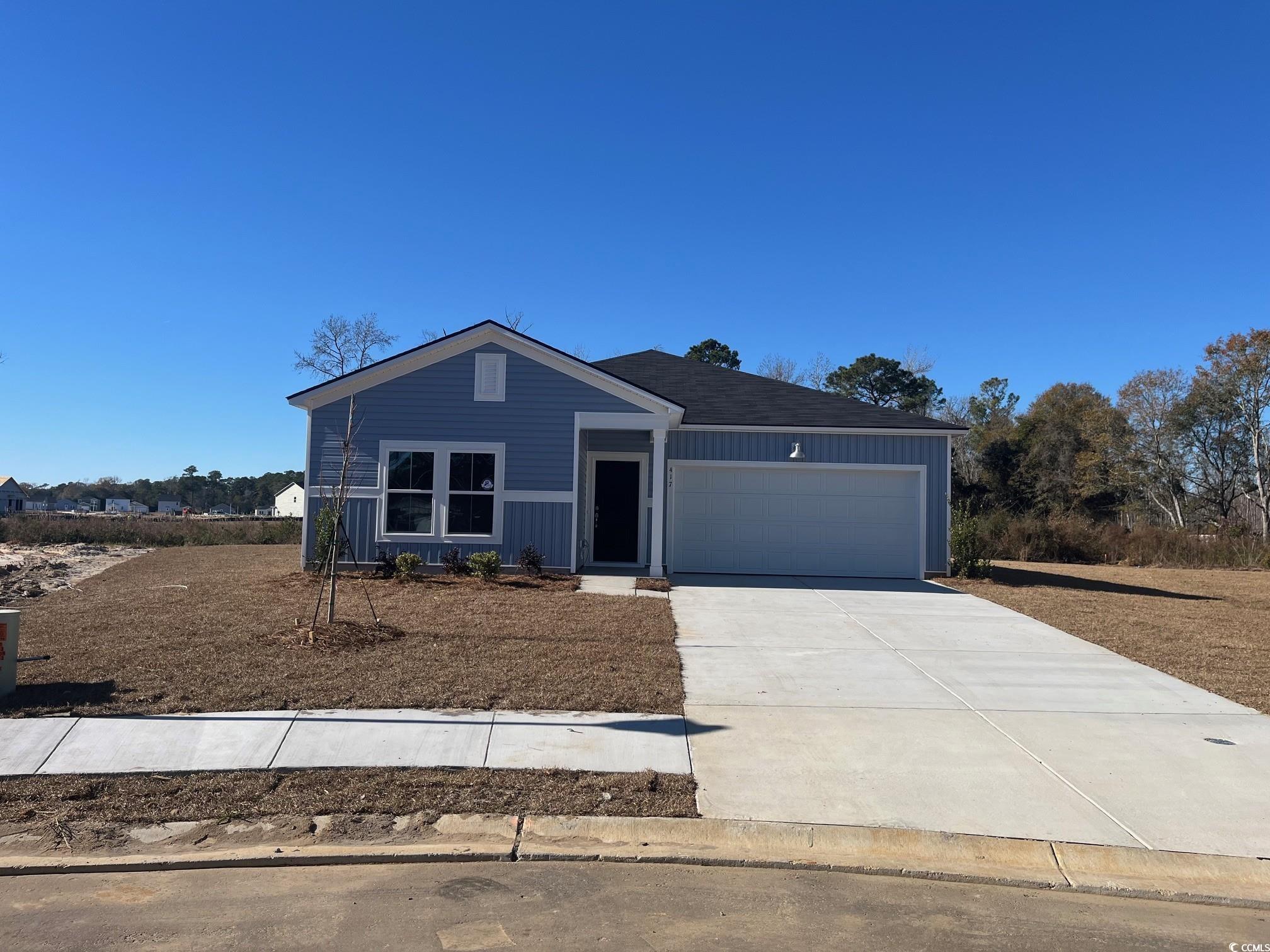 View of front of house with concrete driveway and an attached garage