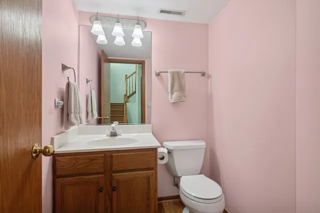 a bathroom with a sink vanity mirror and toilet