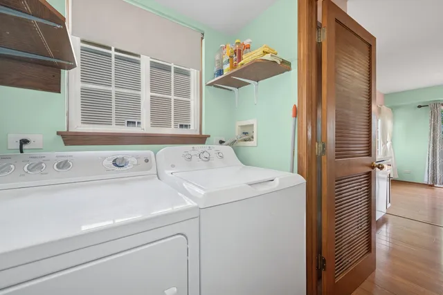 a view of washer and dryer with bathroom in the background