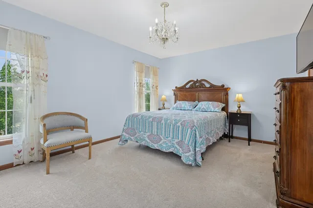 a bedroom with a bed chair and window