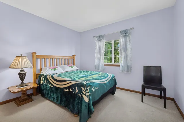 a bedroom with a bed and a lounge chair