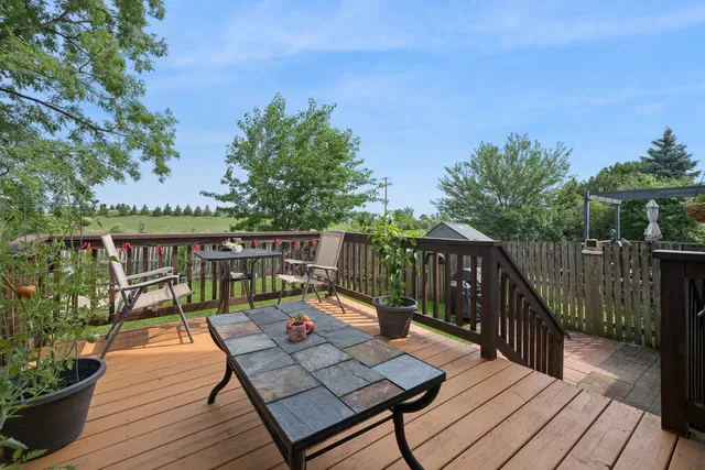a balcony with wooden floor table and chairs