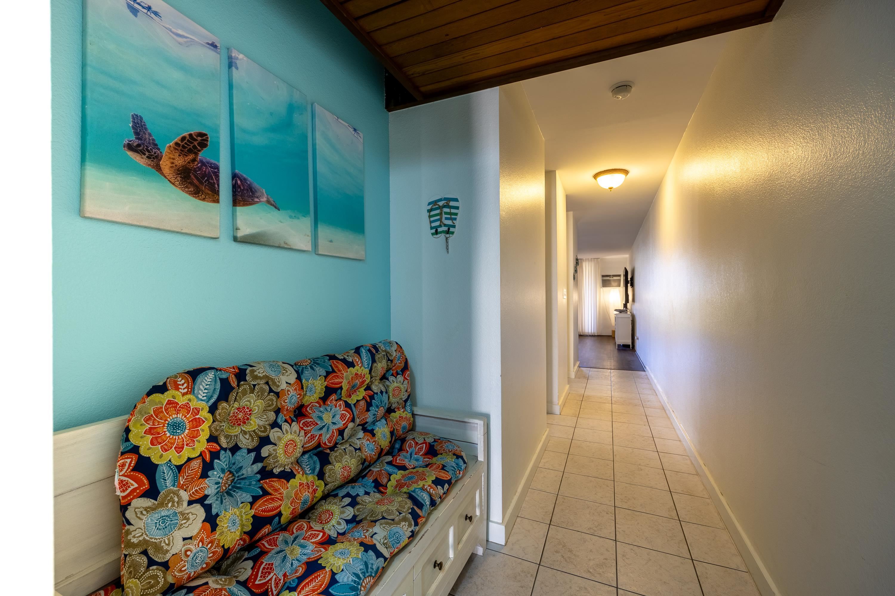 2695 South Kihei Road, Unit 9209 Kihei, HI 96753 - Photo 8 of 50 a hallway with painting on the wall and a large window