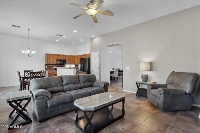 a living room with furniture kitchen view and a chandelier