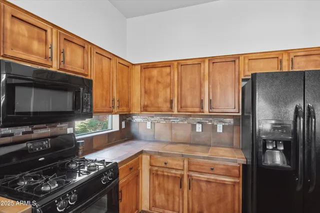 a kitchen with stainless steel appliances granite countertop a refrigerator stove and sink
