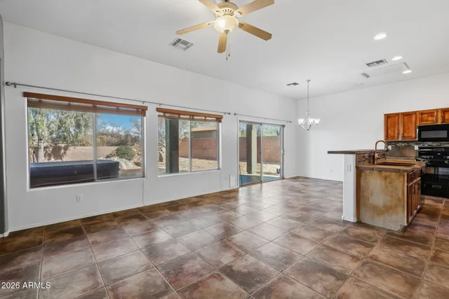 an empty room with closet and a chandelier fan