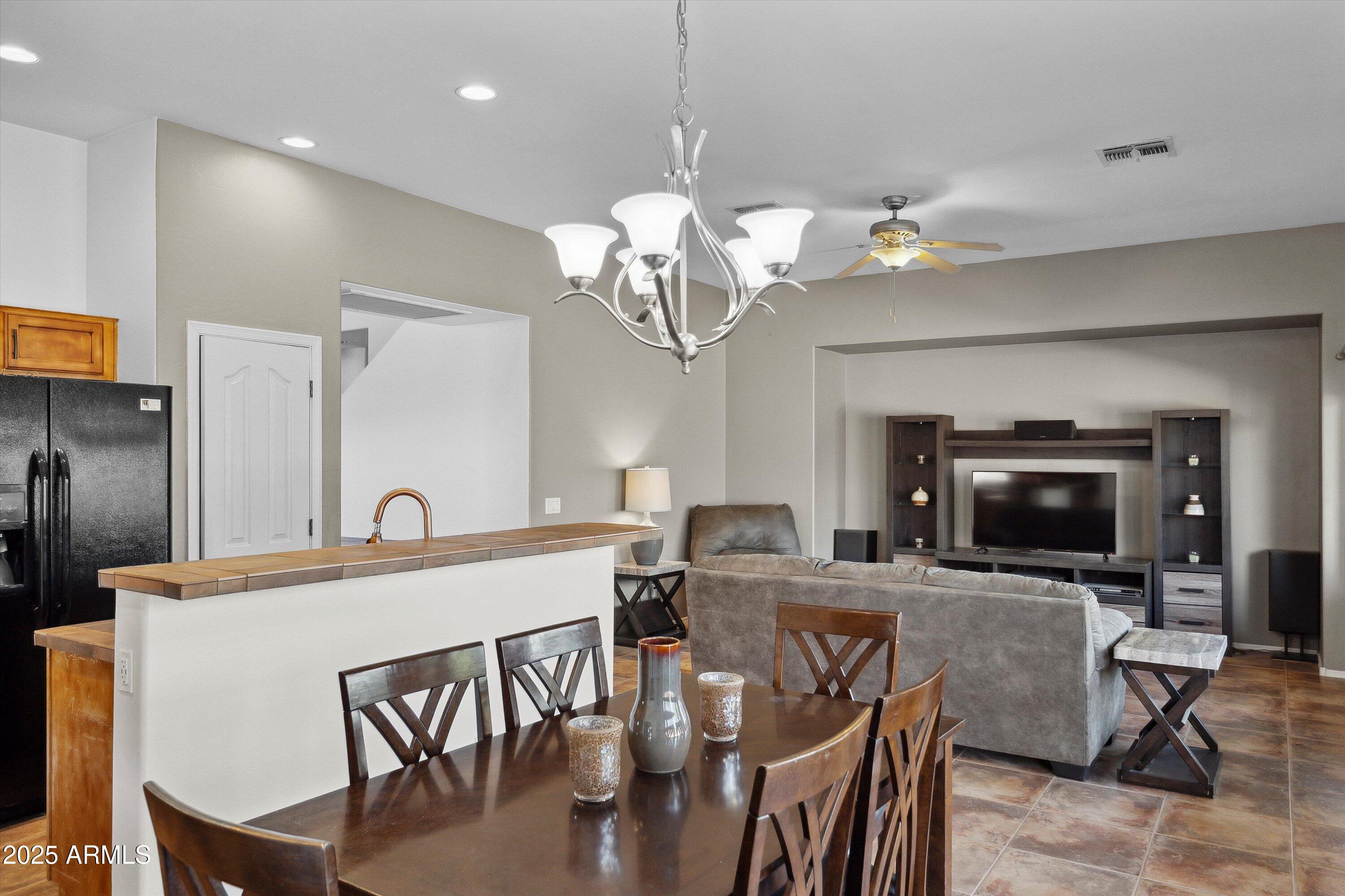 17407 South Purple Mesa Trail Vail, AZ 85641 - Photo 16 of 54 a view of a dining room with furniture a chandelier and wooden floor