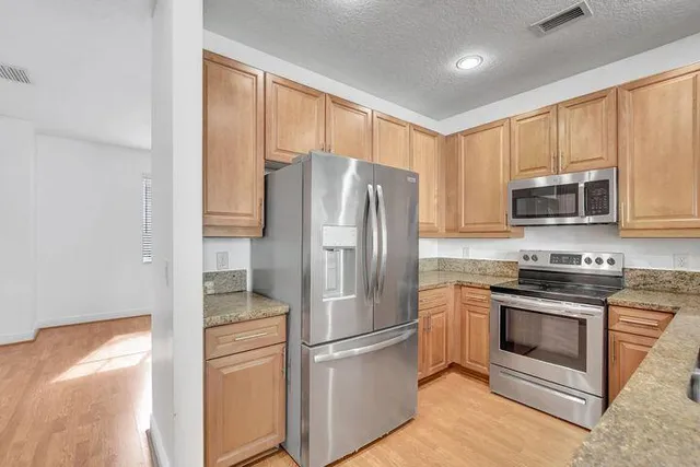 a metallic refrigerator freezer sitting inside of a kitchen