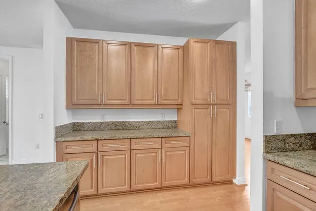 a kitchen with granite countertop cabinets and white appliances