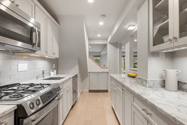 a kitchen with stainless steel appliances granite countertop a stove and a sink