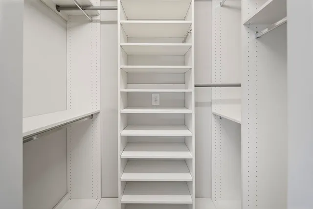 a view of walk in closet with empty racks