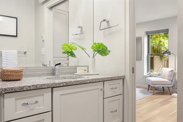a bathroom with a granite countertop sink a toilet and a mirror