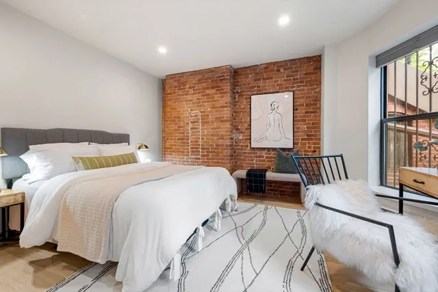 a bedroom with a bed and a large window